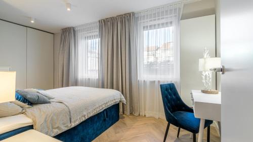 een slaapkamer met een bed, een bureau en een stoel bij HvileStay Sopot - prywatne miejsce parkingowe in Sopot