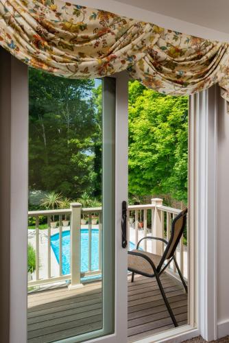 a sliding glass door with a chair on a porch at The Winstead Inn in Harwich