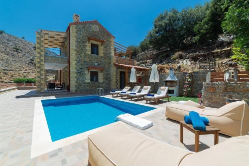 a swimming pool with lounge chairs and a house at Faraggi Villas in Zonianá