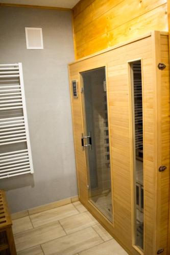 a bathroom with a glass door and a window at Apartmány Karolin in Uhorská Ves