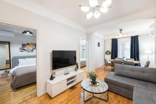 a living room with a couch and a tv and a bed at Porto Sea View Apartments - Kypriou in Thessaloniki