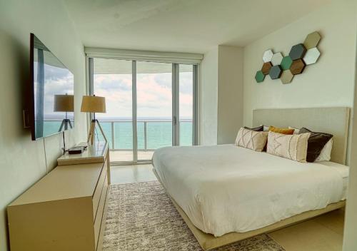 a bedroom with a large bed and a large window at Lyfe Resort on Miami Hollywood BeachFront by MRA in Hollywood