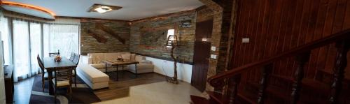 a living room with a table and a brick wall at Pamporovo Villa in Pamporovo