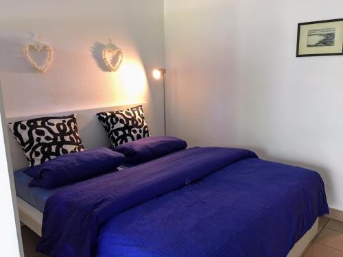 a bedroom with two beds with purple blankets and pillows at Ostseeresidenz - App 08 Meeresrauschen in Zingst