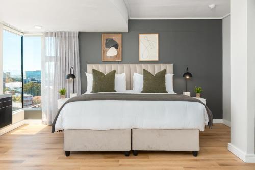 sypialnia z dużym łóżkiem i dużym oknem w obiekcie Point Break Luxury Apartments w Kapsztadzie