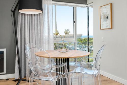 a dining room with a table and chairs and a window at Point Break Luxury Apartments in Cape Town