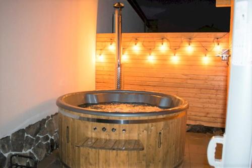 a bathroom with a sink in a barrel with lights at Apartmány Karolin in Uhorská Ves