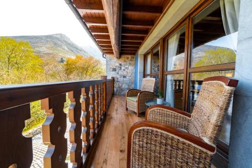 a balcony with chairs and a view of the mountains at Hotel Rural El Pandal in Ardisana