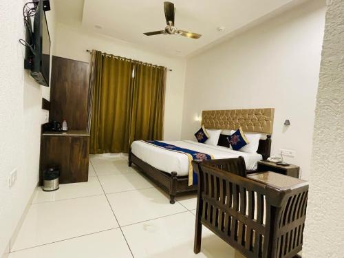 a bedroom with a bed and a chair in a room at Clover Inn in Udaipur