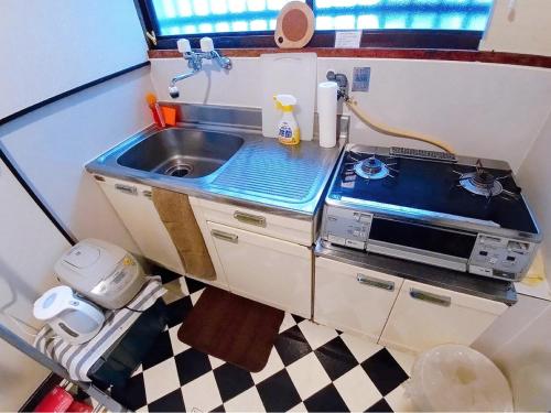 uma cozinha em miniatura com um lavatório e um micro-ondas em Hakko Ichiu em Osaka