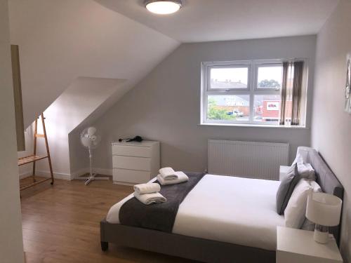 ein Schlafzimmer mit einem Bett mit zwei Handtüchern darauf in der Unterkunft 2nd Floor Town Centre Apt with FREE Parking in Loughborough