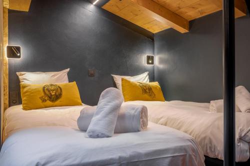 Cette chambre comprend 2 lits avec des oreillers jaunes et blancs. dans l'établissement Duplex avec sauna et vue MontBlanc, à Chamonix-Mont-Blanc