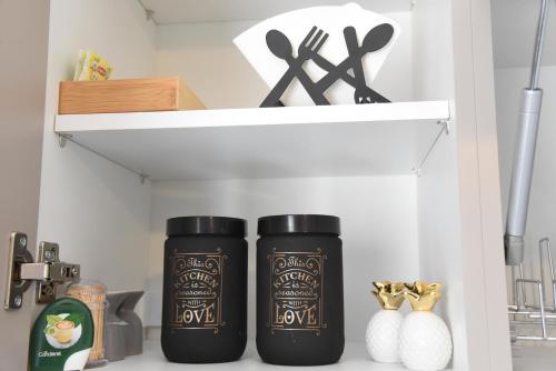 two black bottles sitting on a shelf in a kitchen at Memory House in Megara