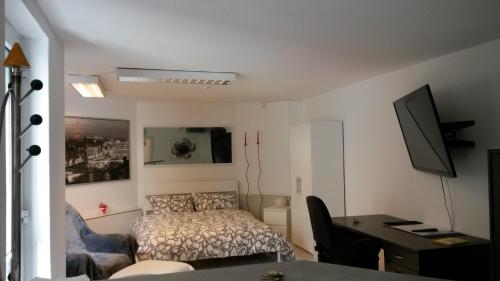 Habitación pequeña con cama, escritorio y escritorio. en Ferienwohnung Bella, en Coblenza