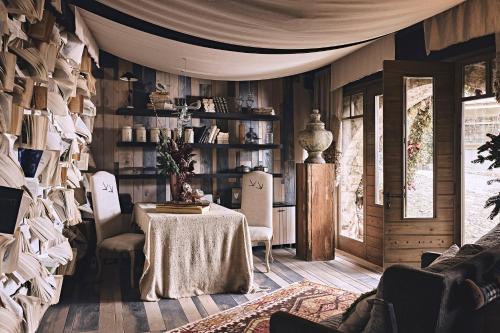 une salle à manger avec une table et une étagère à livres dans l'établissement Area Synest Nature Suites, à Sinevrón