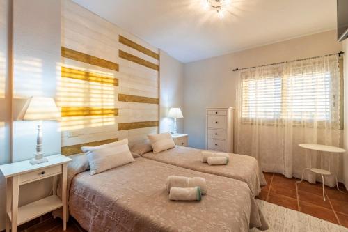 a bedroom with a bed and a table and a lamp at MEDANO4YOU The Rosuca Holiday Home in El Médano
