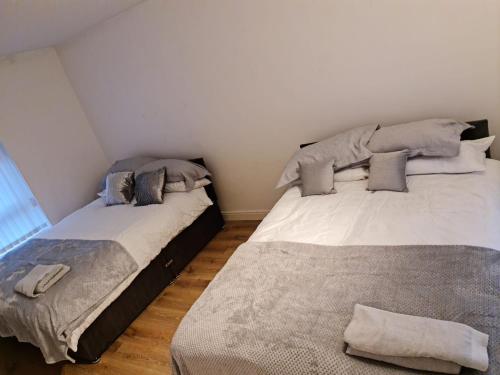 two beds sitting next to each other in a room at 24 Dryden Road - Beautiful 2 bed in Longley