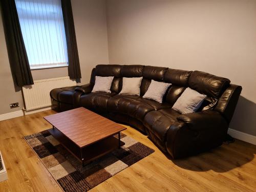 a leather couch in a living room with a coffee table at 24 Dryden Road - Beautiful 2 bed in Longley