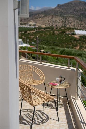 a table and chair on a balcony with a view at Dolce Evita in Makry Gialos