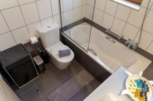 a bathroom with a toilet and a tub and a sink at Dolce Evita in Makry Gialos