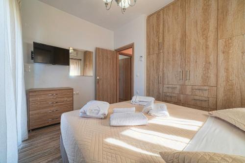a bedroom with a large bed with towels on it at Asfendamos Villas in Zonianá