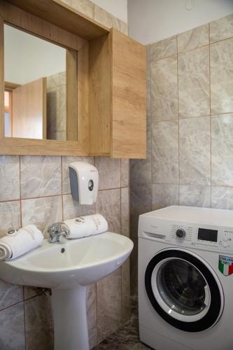 a bathroom with a washing machine and a sink at Asfendamos Villas in Zonianá