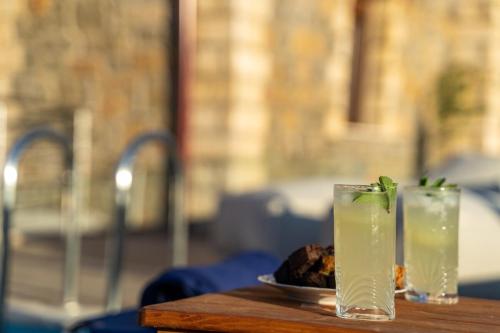 a table with two drinks and a plate of food at Asfendamos Villas in Zonianá