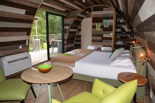 Zimmer mit einem Bett, einem Tisch und Stühlen in der Unterkunft Lodges des grands crus in Chablis