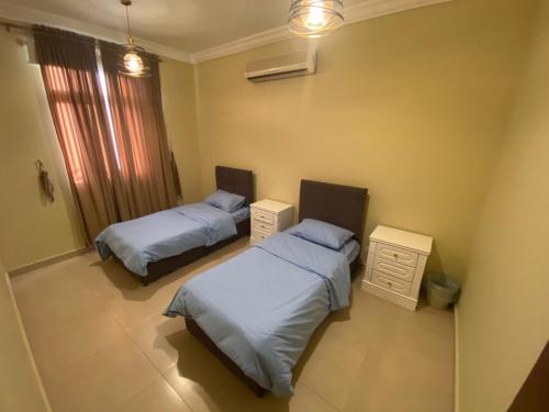 a bedroom with two beds and a window at شاليه درة العروس in Durat  Alarous