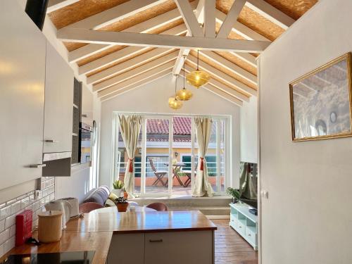a kitchen with a wooden ceiling and a dining room at Janelas Verdes - Peaceful Views in Lisbon