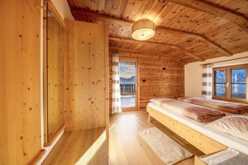 Blockhausschlafzimmer mit einem Bett und einem Fenster in der Unterkunft Malgorerhof Sonja in Jenesien