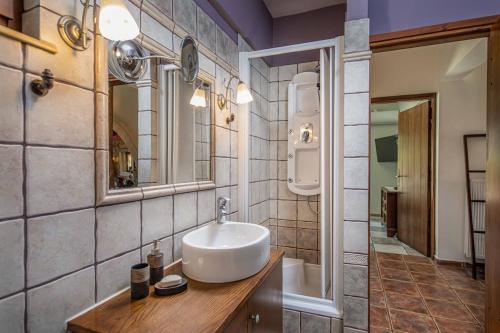 a bathroom with a sink and a mirror and a tub at Villa Staras - With Private Heated Pool & Jacuzzi in Gerani
