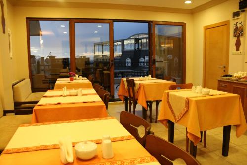 a restaurant with tables and chairs with yellow table cloth at Grand Peninsula Hotel in Istanbul