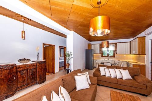 a living room with a couch and a kitchen at Villa Avra - With Private Pool in Melidhónion