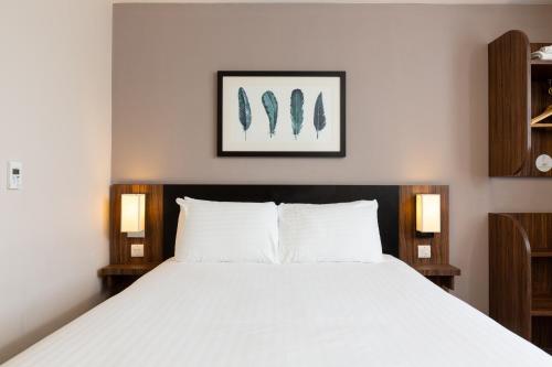 a bedroom with a large white bed with two lamps at Sweet Chestnut, Dunfermline by Marston's Inns in Dunfermline