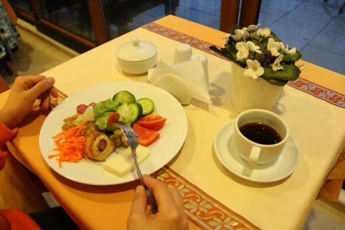een tafel met een bord eten en een kopje koffie bij Grand Peninsula Hotel in Istanbul