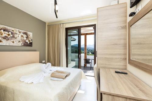 a bedroom with a bed and a view of a balcony at Villa Chnaris - Private Pool and Sauna in Perama