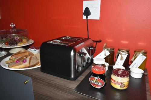 a counter with a toaster and a plate of bread at Mosswood Bed & Breakfast in Graskop