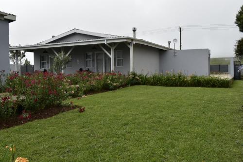 a house with a lawn in front of it at Mosswood Bed & Breakfast in Graskop