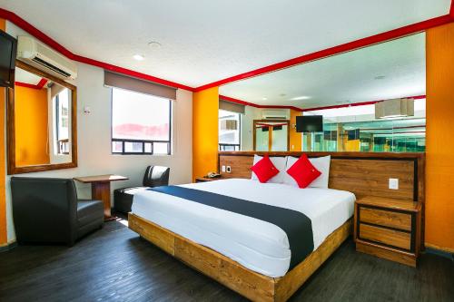 Schlafzimmer mit einem Bett, einem Schreibtisch und einem TV in der Unterkunft Capital O Hotel Casa Blanca, Morelia in Morelia