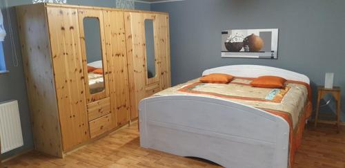 Schlafzimmer mit einem Bett und einem Holzschrank in der Unterkunft Ferienwohnung Gutwin in Bischofsheim an der Rhön