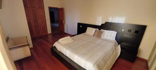 a bedroom with a large bed with white sheets at Quinta do Carvalho - Nature Guest Houses in Guimarães