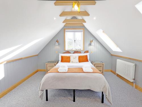 una camera da letto con un grande letto in mansarda di Silhouette's Stables, West Ashling a Chichester