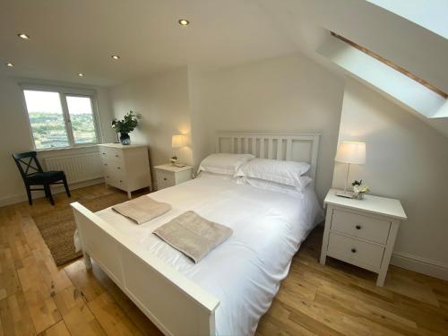 1 dormitorio con 1 cama blanca grande y escritorio en Pass The Keys Beautiful 3 Bedroom House with Great Views of Bath, en Bath