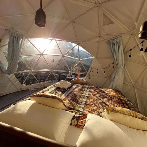 um quarto com uma cama numa tenda em เตนท์โดมชายดอย ดอยแม่แจ๋ม ลำปาง em Ban Mai