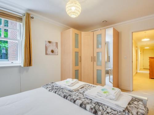 a bedroom with a bed with towels on it at Pass The Keys Quiet 2-Bed Apartment on the Ground Floor in Canterbury