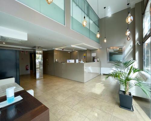 an office lobby with a potted plant in the middle at SM Hotel Teatre Auditori in Barcelona