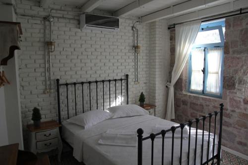 a bedroom with a bed and a brick wall at Cesmeli Han in Ayvalık