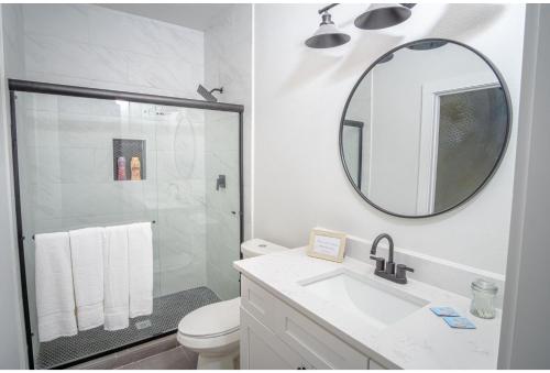 a bathroom with a shower and a sink and a mirror at Spectacular Cozy 3 BR plus 2 and a half BA Apt Near Downtown in San Antonio