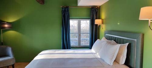 a green bedroom with a bed and a window at CHATEAU DE BRINVILLE in Saint-Sauveur-sur-École